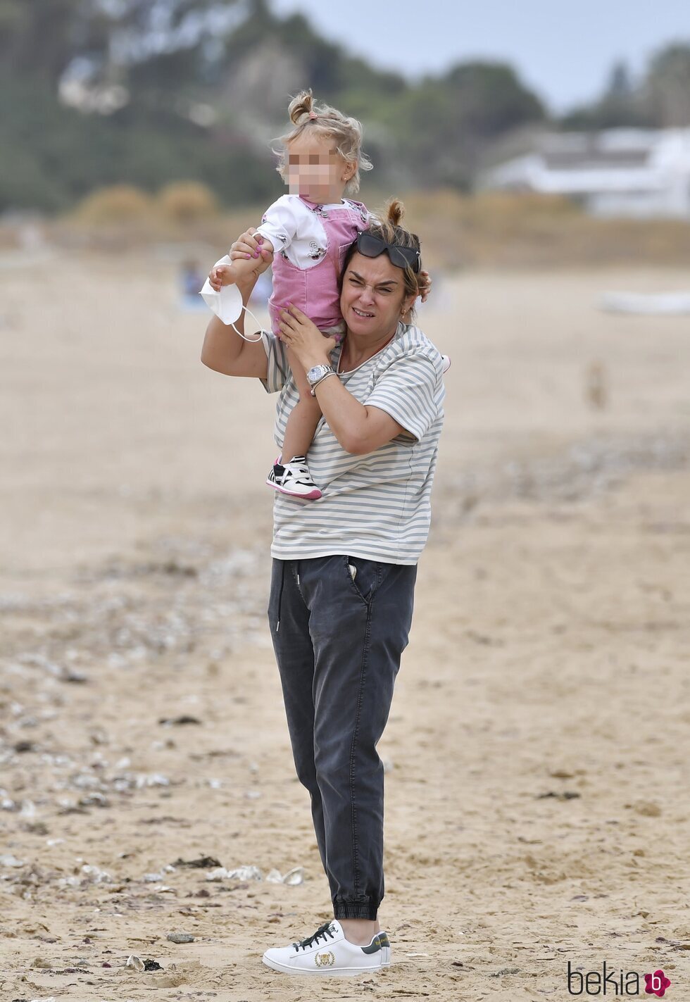 Toñi Moreno con su hija Lola a hombros en la playa