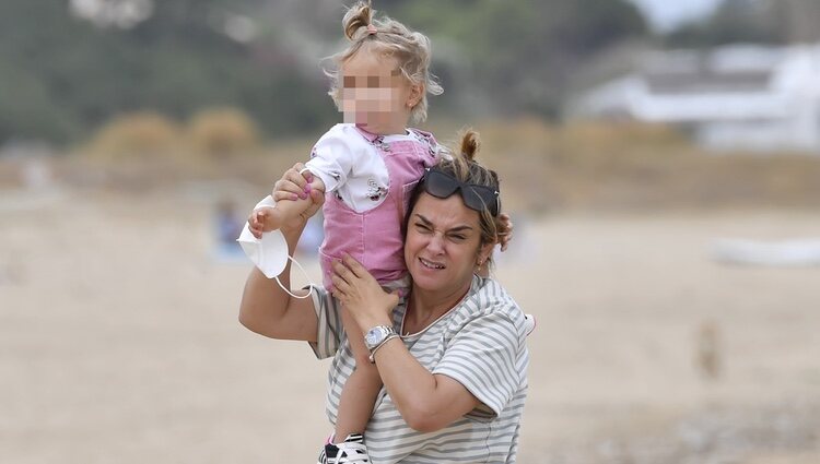 Toñi Moreno con su hija Lola a hombros en la playa