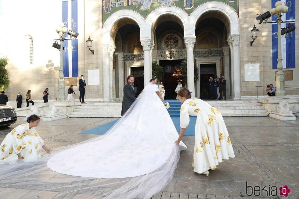 Anne-Marie Morales y Amelia Morales colocan la cola del vestido de novia de Nina Flohr en la boda de Felipe de Grecia y Nina Flohr