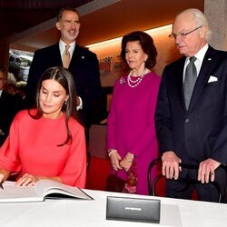 La Reina Letizia firmando en el Museo Nobel en presencia del Rey Felipe y los Reyes de Suecia