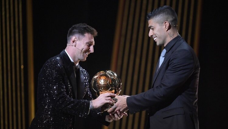Leo Messi recibiendo su Balón de Oro 2021 por Luis Suárez