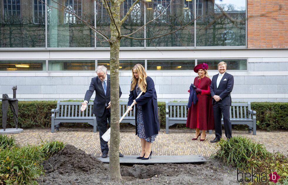 Amalia de Holanda plantando un árbol en presencia de sus padres para conmemorar su entrada en el Consejo de Estado