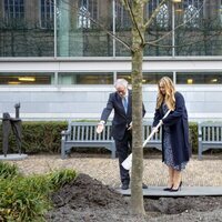 Amalia de Holanda plantando un árbol en presencia de sus padres para conmemorar su entrada en el Consejo de Estado