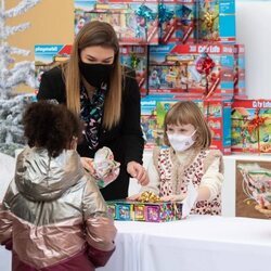 Gabriella de Mónaco da regalos a una niña en presencia de Camille Gottlieb en la entrega de regalos navideños 2021