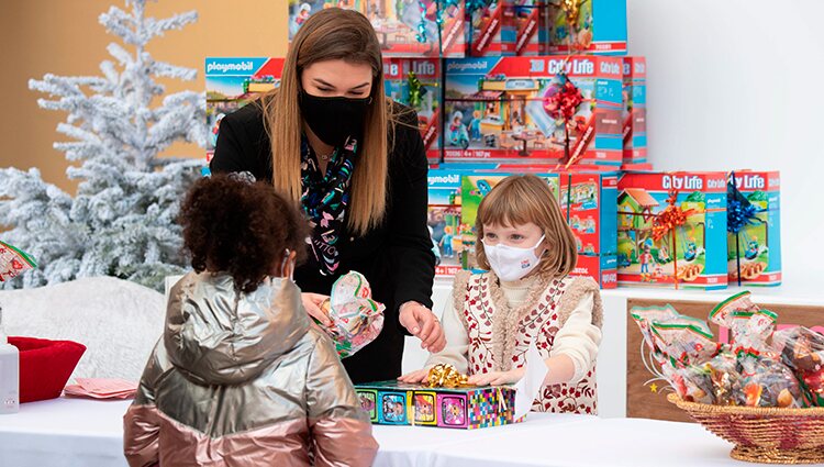 Gabriella de Mónaco da regalos a una niña en presencia de Camille Gottlieb en la entrega de regalos navideños 2021