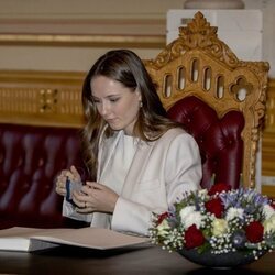 Ingrid Alexandra de Noruega firmando en el libro de visitas del Parlamento de Noruega en su visita por su 18 cumpleaños