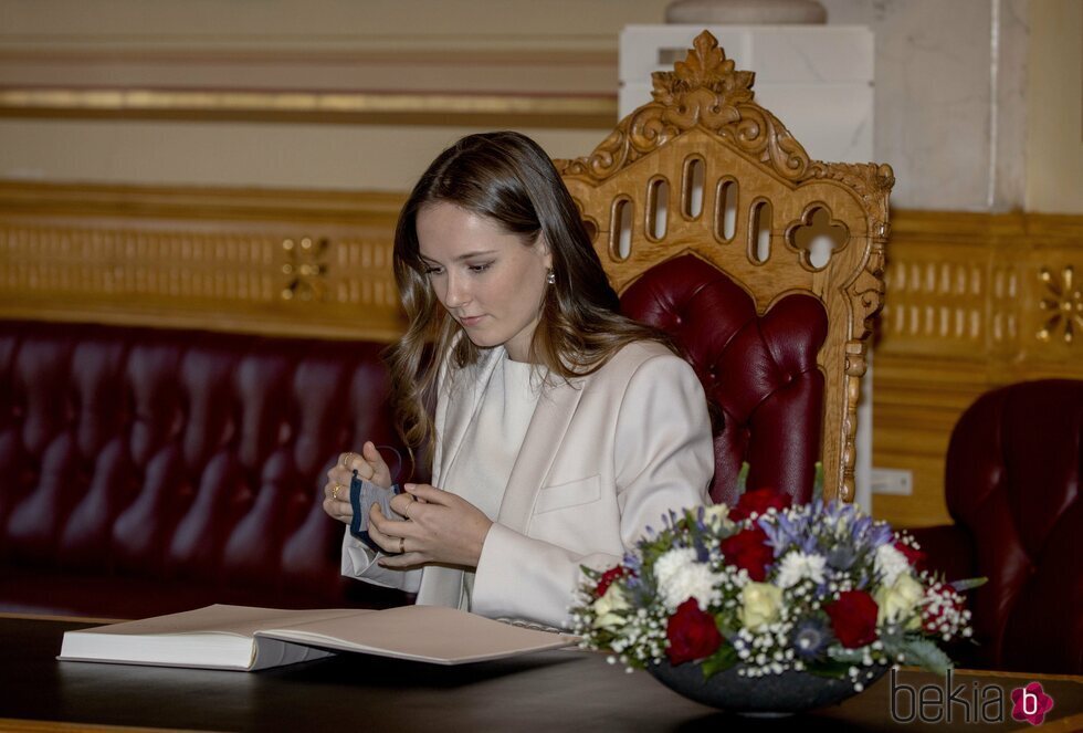 Ingrid Alexandra de Noruega firmando en el libro de visitas del Parlamento de Noruega en su visita por su 18 cumpleaños