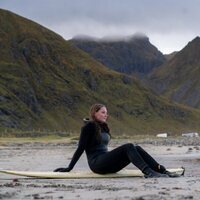 Ingrid Alexandra de Noruega, sentada sobre su tabla de surf