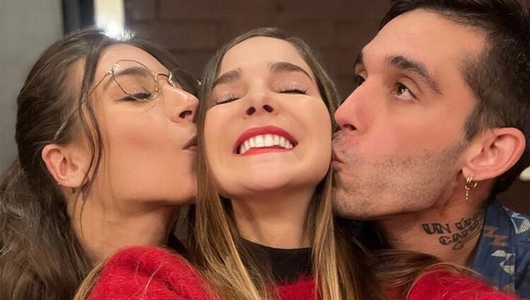 Ana Guerra y Víctor Elías dando un beso en la mejilla a Natalia Sánchez