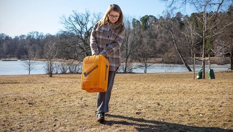 Estela de Suecia con gafas cargando una garrafa de agua en el Día Mundial del Agua
