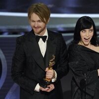 Billie Eilish y Finneas O'Connell con la estatuilla a Mejor Canción Original en los Premios Oscar 2022
