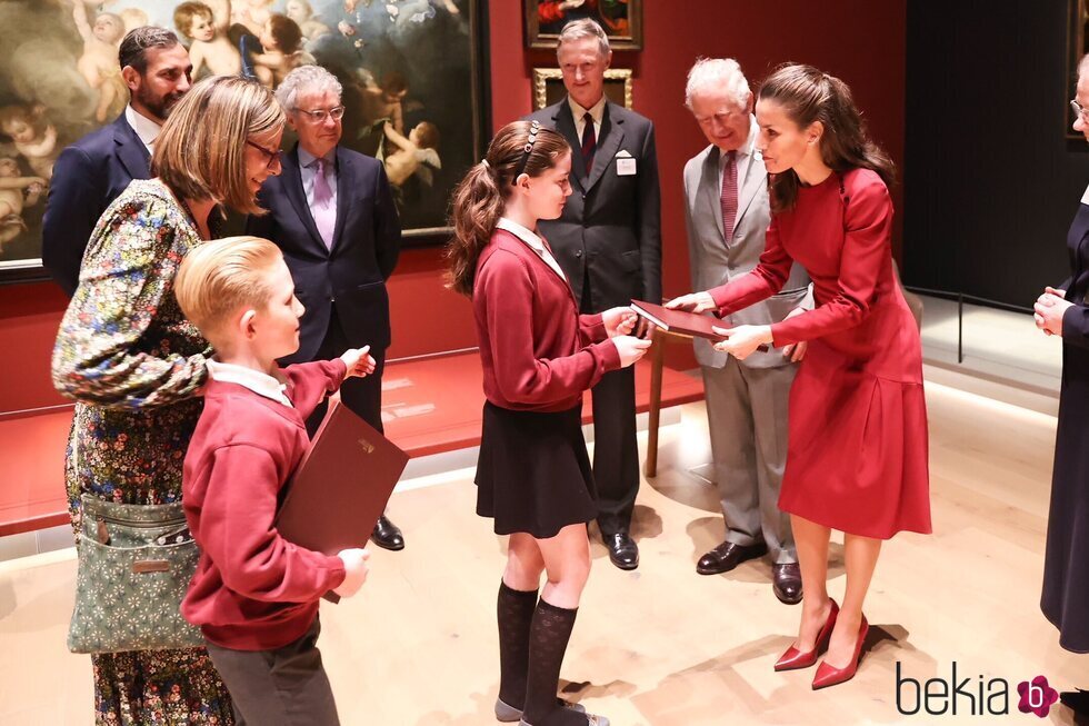 La Reina Letizia recibe un regalo de manos de una niña en presencia del Príncipe Carlos en la inauguración de la Spanish Gallery de Bishop Auckland