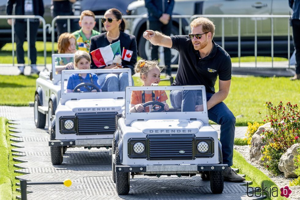 El Príncipe Harry y Meghan Markle montados en unos coches con unos niños en los Invictus Games de La Haya