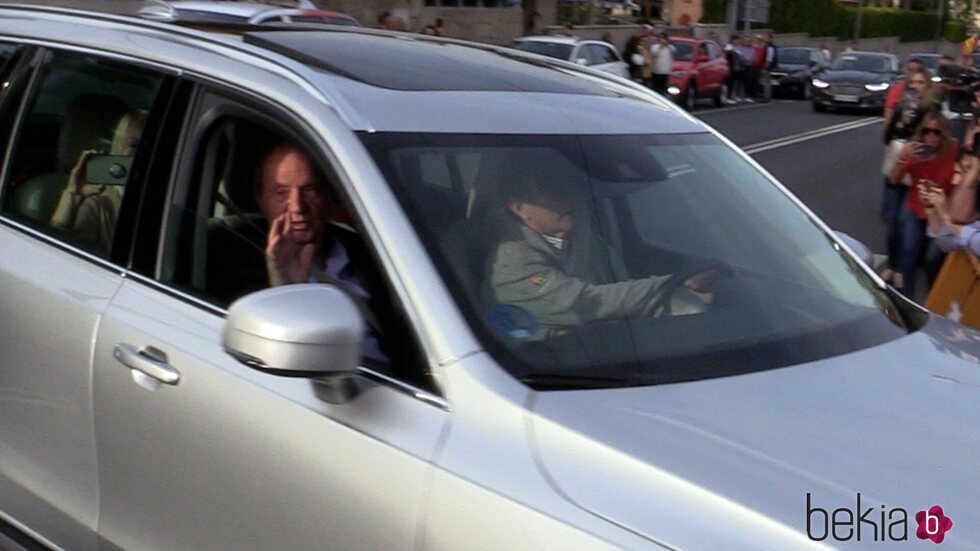 El Rey Juan Carlos saludando desde el coche junto a Pedro Campos a su llegada a Sanxenxo en su regreso a España