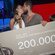 Alejandro Nieto y Tania Medina besándose junto al cheque de ganador en la final de 'Supervivientes 2022'