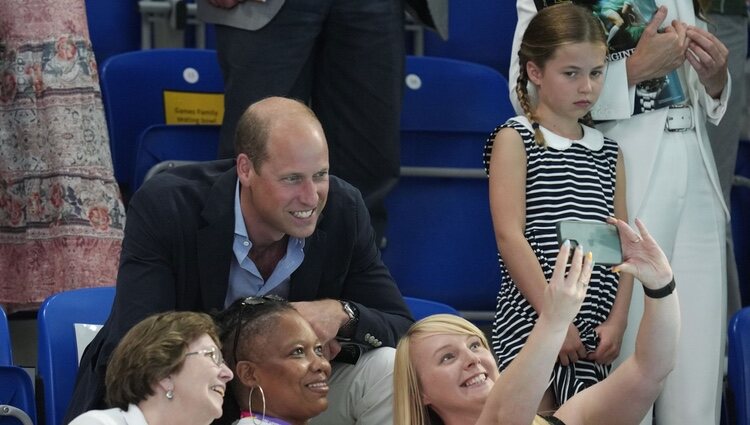 El Príncipe Guillermo se hace un selfie ante la mirada de la Princesa Charlotte en una competición de natación en los Juegos de la Commonwealth 2022