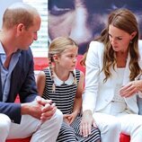 El Príncipe Guillermo y Kate Middleton mirando a la Princesa Charlotte en su visita a SportsAid House