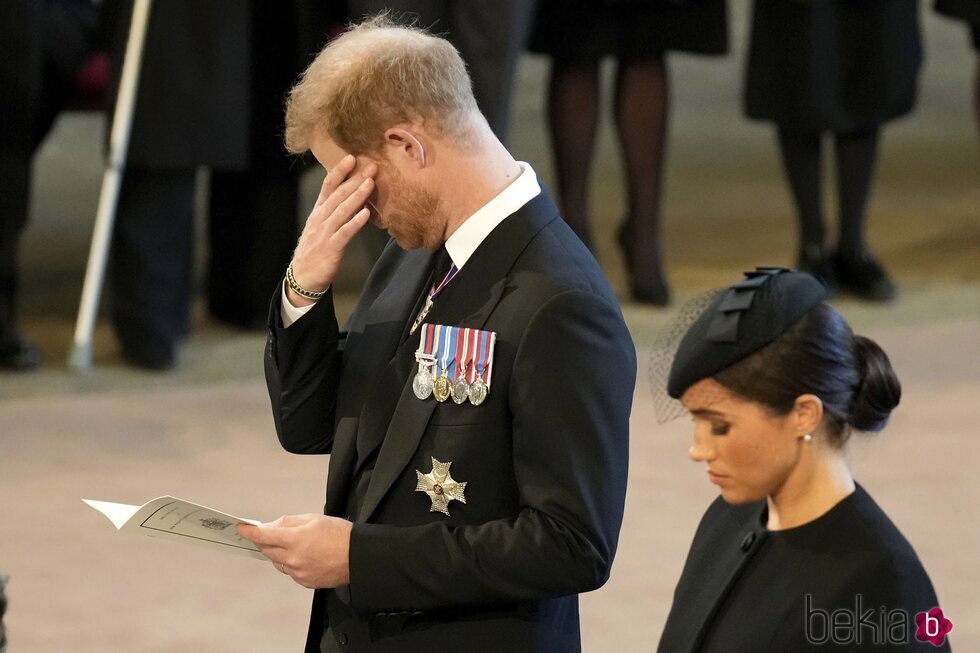 El Príncipe Harry con gesto apenado y Meghan Markle en la misa en Westminster por la Reina Isabel II