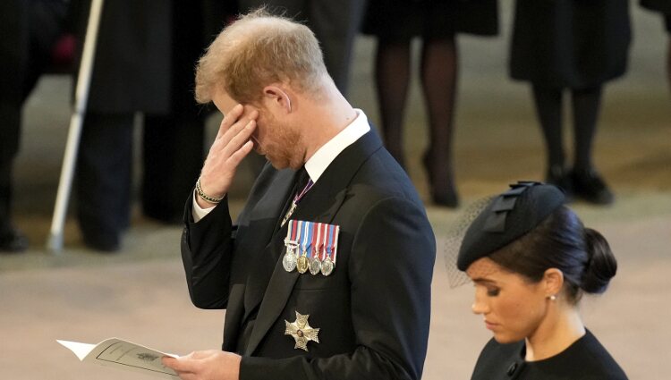 El Príncipe Harry con gesto apenado y Meghan Markle en la misa en Westminster por la Reina Isabel II