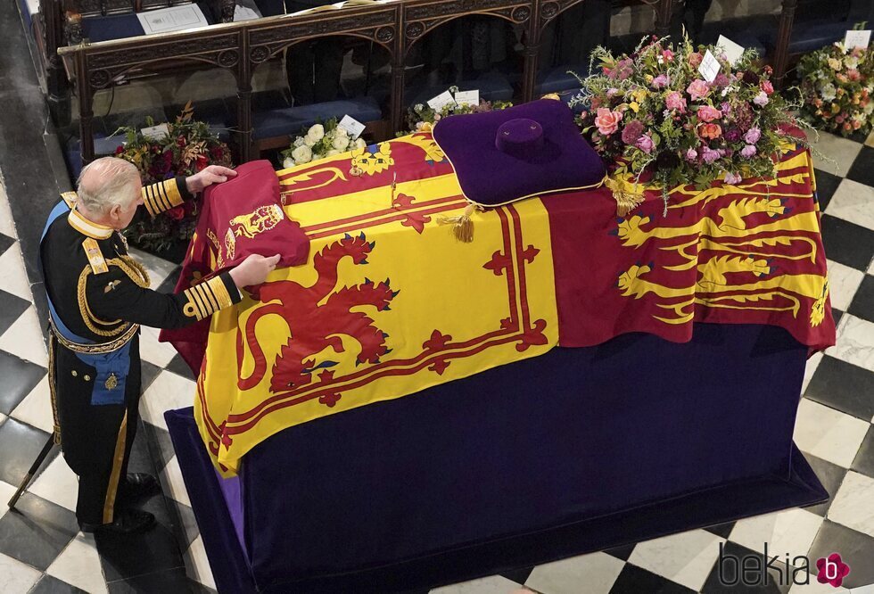 El Rey Carlos III coloca una bandera sobre el féretro de la Reina Isabel II