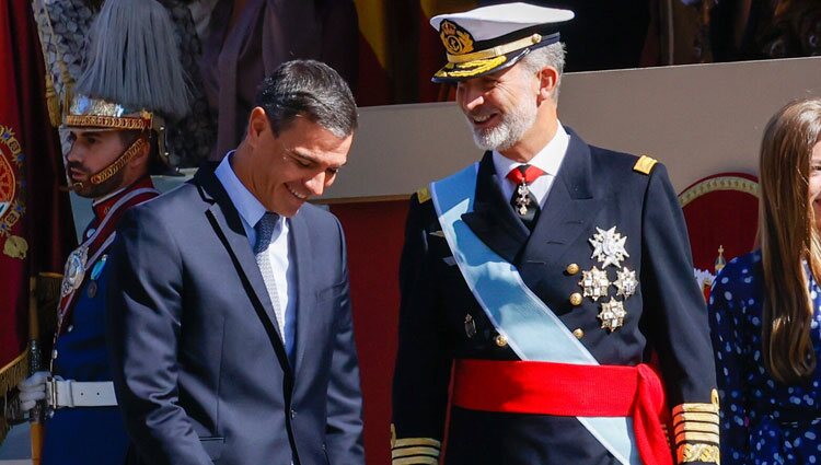 Pedro Sánchez y Felipe VI bromeando en el desfile militar por la Fiesta Nacional 2022