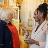 La Reina Camilla y Alexandra Burke hablando en la recepción a los ganadores del Queen's Commonwealth Essay Competition