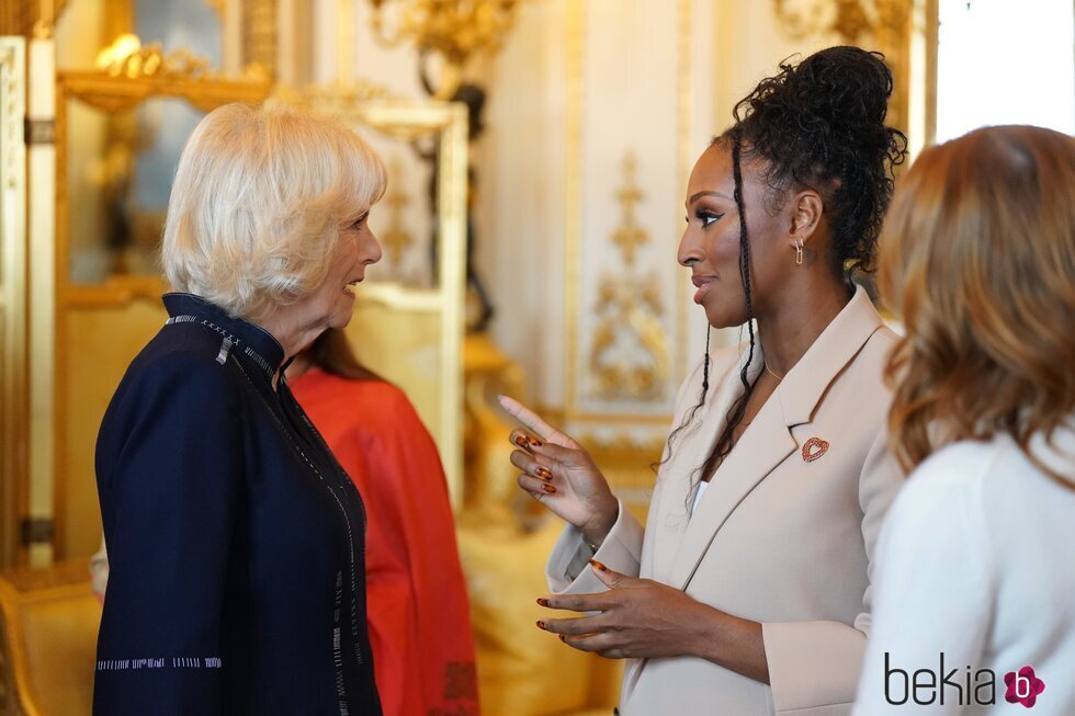 La Reina Camilla y Alexandra Burke hablando en la recepción a los ganadores del Queen's Commonwealth Essay Competition