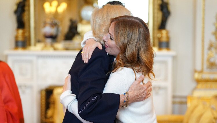 La Reina Camilla y Geri Halliwell dándose un abrazo en la recepción a los ganadores del Queen's Commonwealth Essay Competition