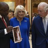 Los Reyes Carlos y Camilla y el Presidente de Sudáfrica con una foto de la Reina Isabel II y Nelson Mandela