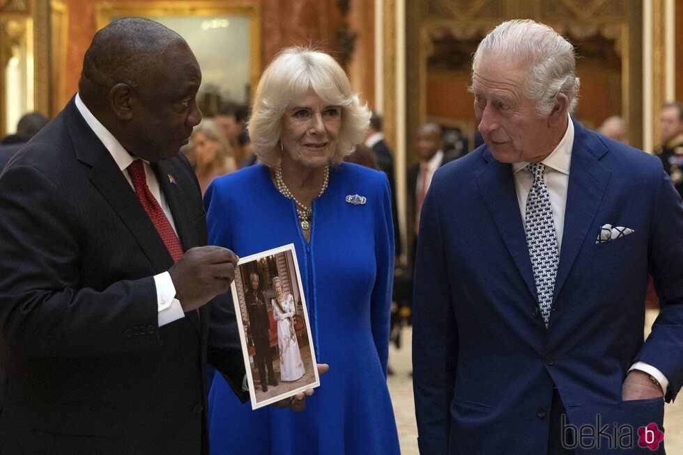 Los Reyes Carlos y Camilla y el Presidente de Sudáfrica con una foto de la Reina Isabel II y Nelson Mandela