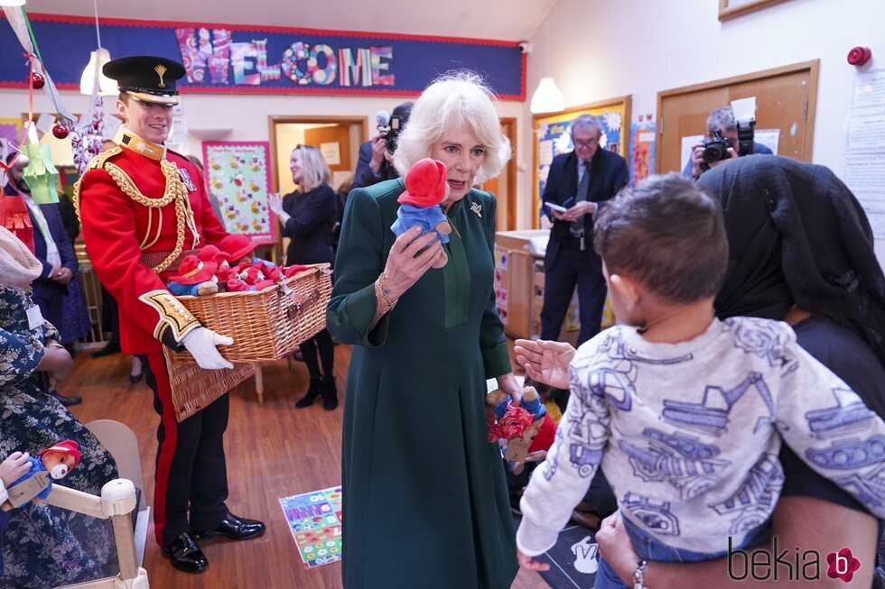 La Reina Camilla entrega un osito Paddington a un niño