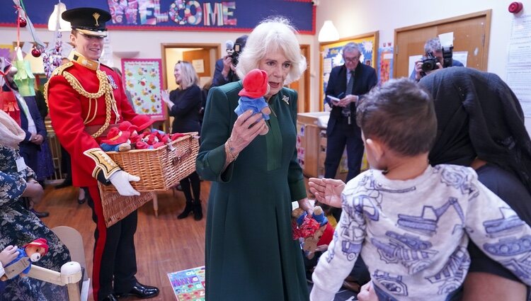 La Reina Camilla entrega un osito Paddington a un niño