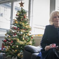 La Reina Camilla junto a un árbol de Navidad durante su visita a The Emmaus Community en Bobby Vincent House