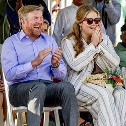 Guillermo Alejandro de Holanda y Amalia de Holanda riéndose en una ceremonia de bienvenida en Aruba