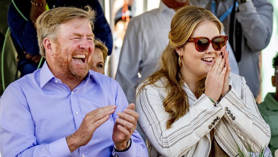 Guillermo Alejandro de Holanda y Amalia de Holanda riéndose en una ceremonia de bienvenida en Aruba