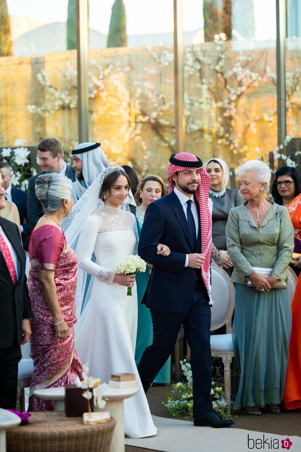Muna de Jordania mirando a sus nietos Iman de Jordania y Hussein de Jordania en la boda de Iman de Jordania