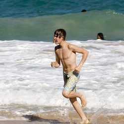 Justin Bieber corriendo en la playa con el torso desnudo