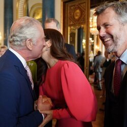 Carlos III besa a Mary de Dinamarca en presencia de Federico de Dinamarca en la recepción previa a la coronación de Carlos III