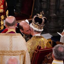 El Príncipe Guillermo besa a su padre, el Rey Carlos III, en el servicio de la Coronación