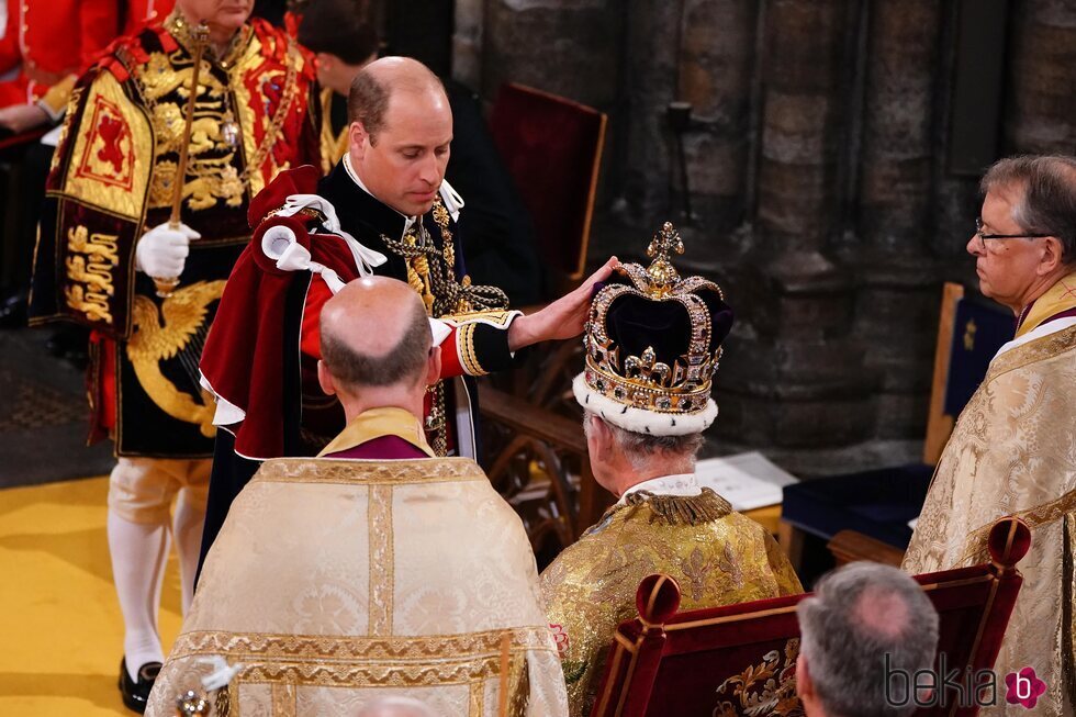 El Príncipe Guillermo posa su mano sobre la corona del Rey Carlos III