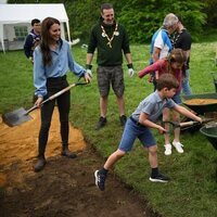El Príncipe Louis echando tierra en una carretilla en presencia de Kate Middleton y la Princesa Charlotte en the Big Help Out por la Coronación
