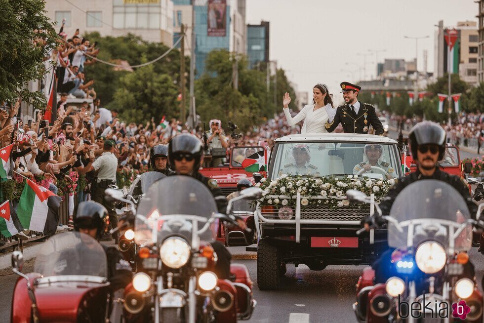 Hussein y Rajwa de Jordania saludando en la caravana roja en su boda