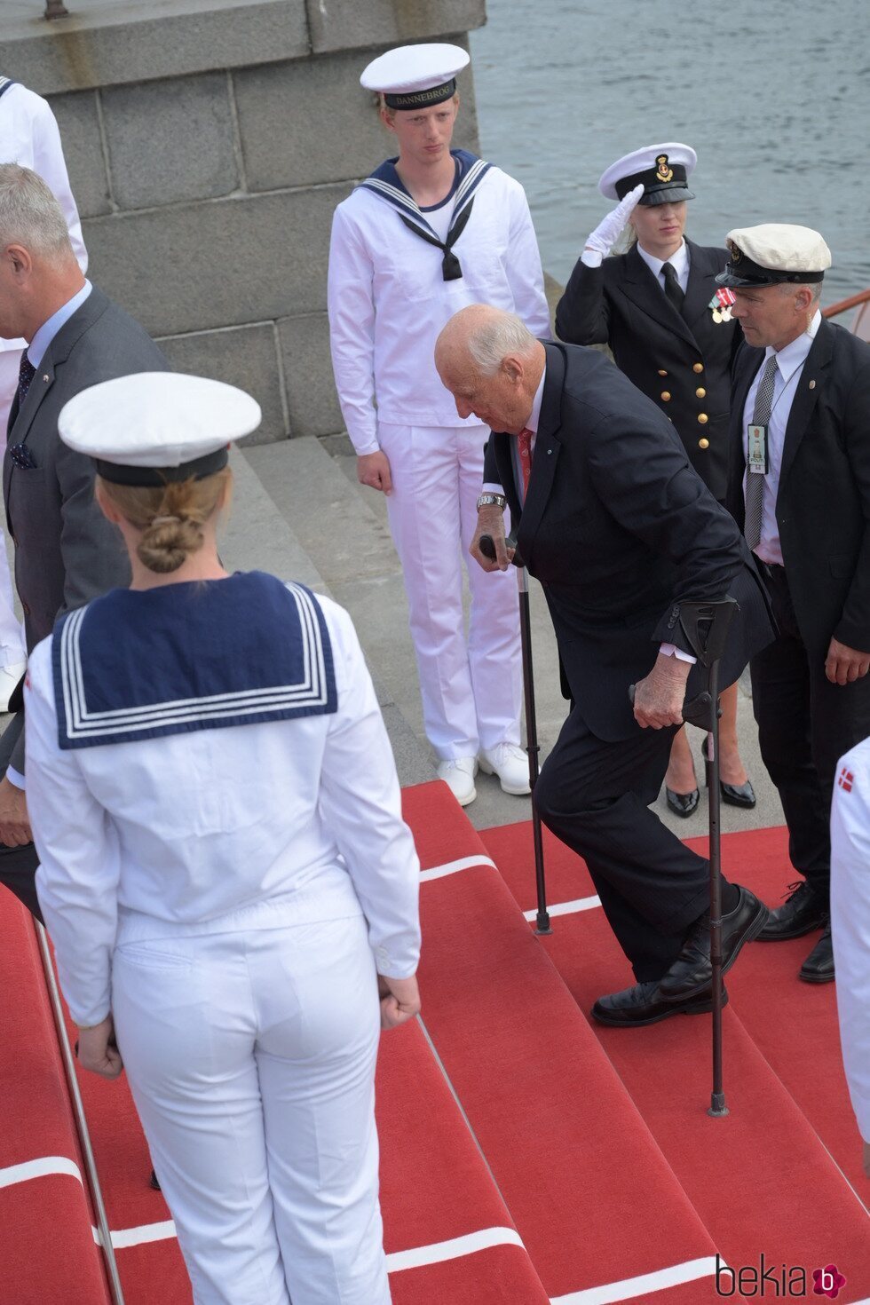 Harald de Noruega subiendo las escaleras con muletas en su visita oficial a Dinamarca