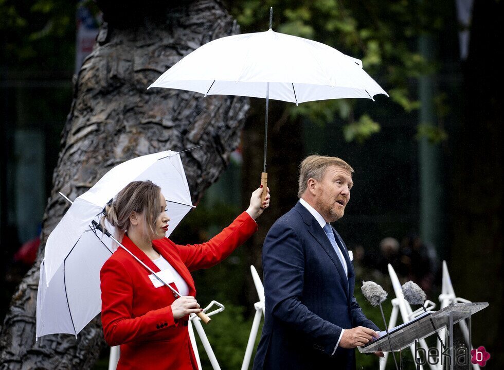 Guillermo Alejandro de Holanda pronuncia su discurso sobre la esclavitud mientras le tapan con un paraguas