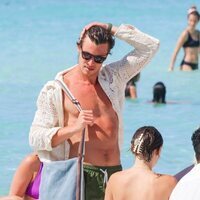 Shawn Mendes con camisa y bolsa en la playa en Ibiza