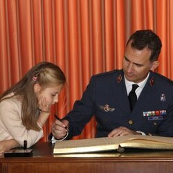 La Princesa Leonor mirando cómo firma el Rey Felipe VI en la Academia General del Aire de San Javier en una foto inédita por su 18 cumpleaños