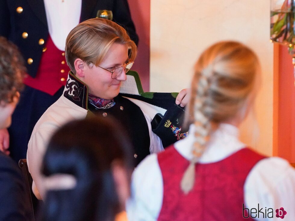 Sverre Magnus de Noruega mostrando el bordado de Sonia de Noruega en su bunad en el almuerzo por su 18 cumpleaños