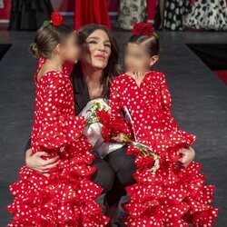 Raquel Bollo y sus nietas besándola durante la SIMOF 2024
