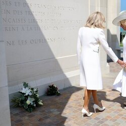 Brigitte Macron tratando de coger de la mano a la Reina Camilla en el 80 aniversario del Desembarco de Normandía