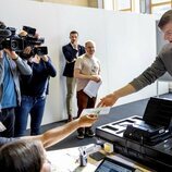 Emmanuel de Bélgica coge su documento de identidad tras haber votado por primera vez